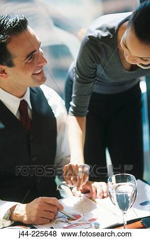 Businessman and woman working in a hotel room while having breakfast View Large Photo Image Stock Photo - Businessman and woman working in a hotel room while having breakfast. Fotosearch