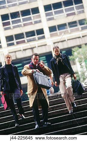 Businessman and women walking down the stairs in the street View Large Photo Image Stock Photography - Businessman and women walking down the stairs in the street. Fotosearch