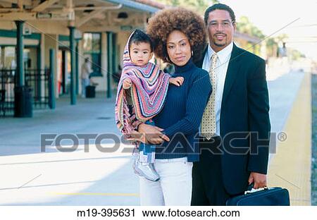 Stock Image - businessman at train station with family. Fotosearch