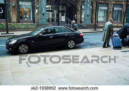 Businessman carrying luggage out from the car, London, UK View Large Photo Image Stock Image - Businessman carrying luggage out from the car, London, UK. Fotosearch