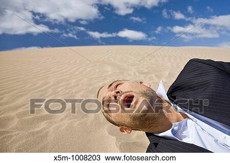 Businessman dying in the desert sun with sand all over his face View Large Photo Image Stock Image - Businessman dying in the desert sun with sand all over his face. Fotosearch