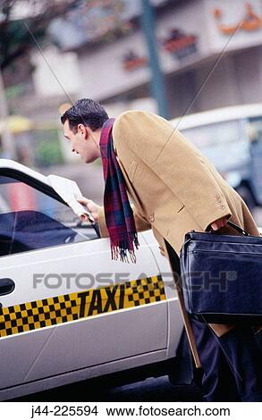 Picture - Businessman getting a taxi cab on the street. Fotosearch