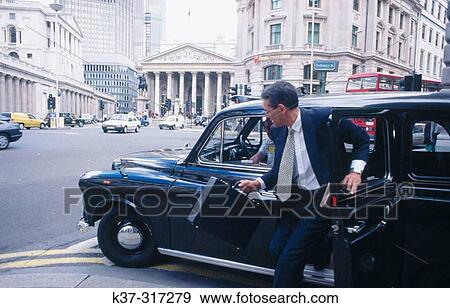 Stock Photo - Businessman getting out of taxi cab in financial district. City of London. Fotosearch