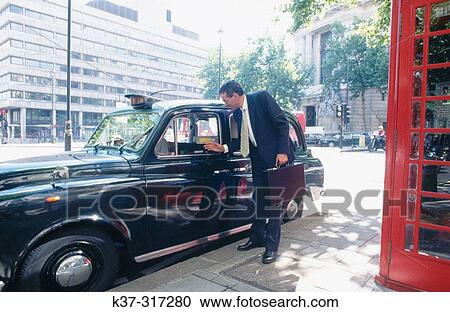 Businessman getting out of taxi cab, red telephone booth in foreground. City of London View Large Photo Image Stock Image - Businessman getting out of taxi cab, red telephone booth in foreground. City of London. Fotosearch