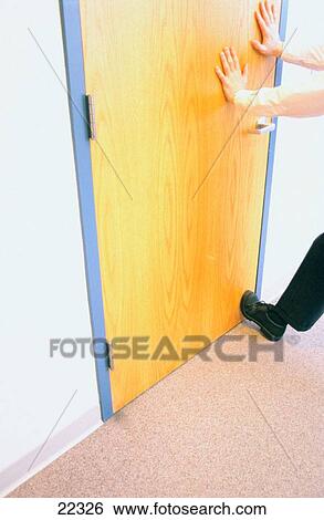 Stock Photograph - Businessman holding office door shut. Fotosearch