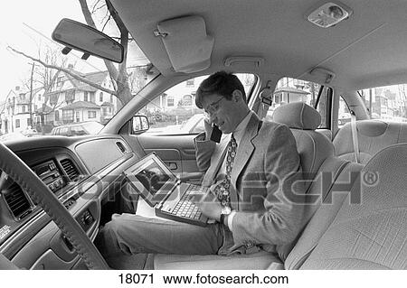 Businessman in car with cell phone and laptop computer View Large Photo Image Stock Image - Businessman in car with cell phone and laptop computer. Fotosearch
