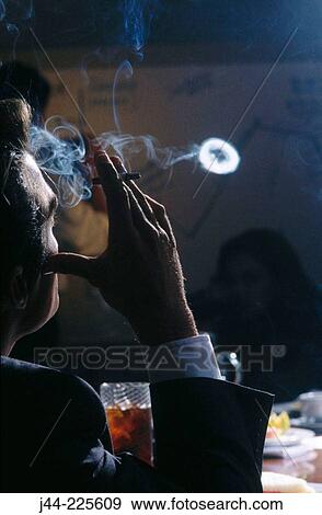 Businessman in conference room smoking cigarrette View Large Photo Image Stock Photo - Businessman in conference room smoking cigarrette. Fotosearch