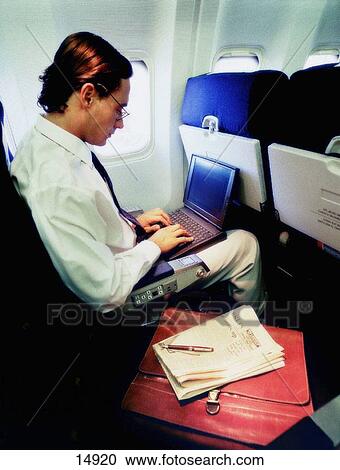 Stock Image - Businessman in plane. Fotosearch