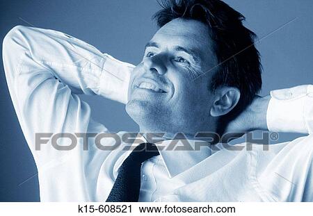 Businessman in shirt & tie sitting back with hands on head smiling View Large Photo Image Stock Image - Businessman in shirt & tie sitting back with hands on head smiling. Fotosearch
