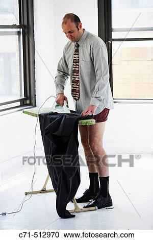 Stock Image - Businessman in underwear ironing his clothes.. Fotosearch