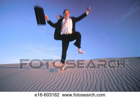 Businessman jumping off sand dunes View Large Photo Image Stock Image - Businessman jumping off sand dunes. Fotosearch