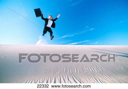Businessman jumping on sand dunes View Large Photo Image Stock Image - Businessman jumping on sand dunes. Fotosearch