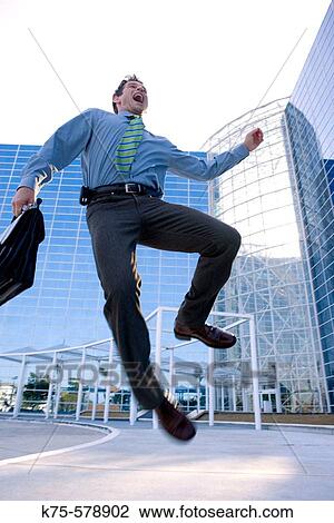businessman jumping with joy outside modern office building View Large Photo Image Stock Image - businessman jumping with joy outside modern office building. Fotosearch