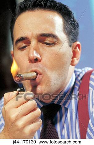 Businessman lighting up a cigar View Large Photo Image Stock Image - Businessman lighting up a cigar. Fotosearch