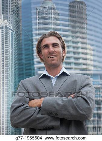 Businessman looking at camera under high rise building. New York, USA View Large Photo Image Picture - Businessman looking at camera under high rise building. New York, USA. Fotosearch