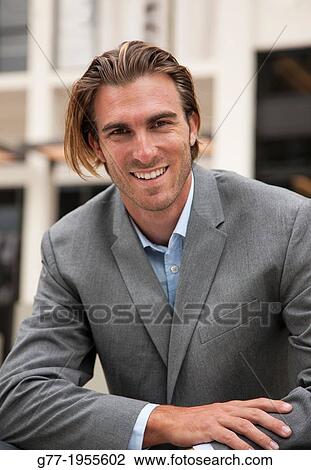 Businessman looking at camera under high rise building. New York, USA View Large Photo Image Stock Image - Businessman looking at camera under high rise building. New York, USA. Fotosearch