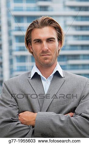 Businessman looking at camera under high rise building. New York, USA View Large Photo Image Stock Image - Businessman looking at camera under high rise building. New York, USA. Fotosearch