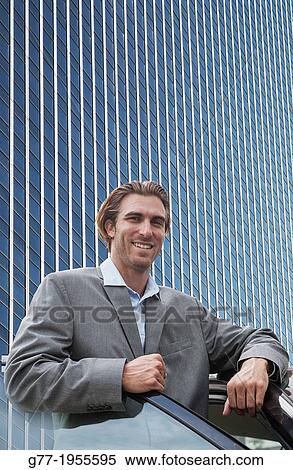 Businessman looking at camera under high rise building. New York. Usa. View Large Photo Image Stock Photography - Businessman looking at camera under high rise building. New York. Usa.. Fotosearch