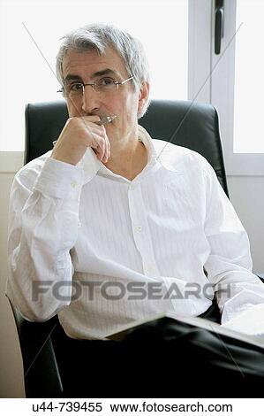 Stock Photography - Businessman looking ath camera posing. Fotosearch