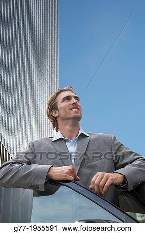 Businessman looking up under high rise building. New York. Usa. View Large Photo Image Stock Image - Businessman looking up under high rise building. New York. Usa.. Fotosearch