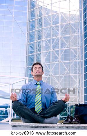 Businessman meditating outside office building View Large Photo Image Stock Image - Businessman meditating outside office building. Fotosearch