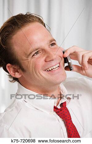 Stock Photo - businessman on cell phone indoors. Fotosearch