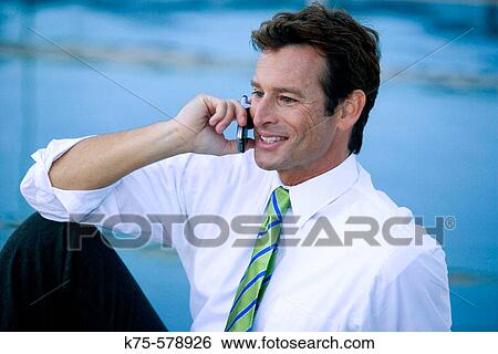 Businessman on cell phone smiling View Large Photo Image Stock Photograph - Businessman on cell phone smiling. Fotosearch
