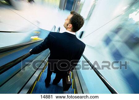Businessman on escalator View Large Photo Image Stock Image - Businessman on escalator. Fotosearch