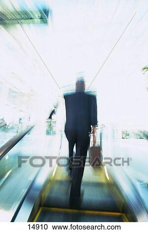 Businessman on escalator View Large Photo Image Stock Image - Businessman on escalator. Fotosearch