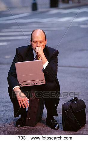Businessman on street with laptop computer View Large Photo Image Stock Image - Businessman on street with laptop computer. Fotosearch