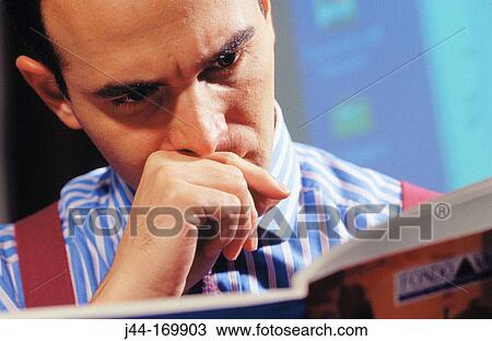 Businessman reading a brochure View Large Photo Image Stock Image - Businessman reading a brochure. Fotosearch