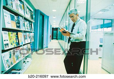 Stock Photo - Businessman reading a magazine. Fotosearch