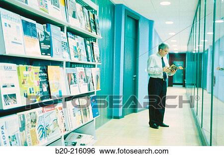 Businessman reading a magazine View Large Photo Image Stock Photograph - Businessman reading a magazine. Fotosearch