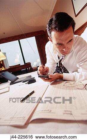 Businessman reading the paper on the bed in a hotel room View Large Photo Image Stock Photograph - Businessman reading the paper on the bed in a hotel room. Fotosearch