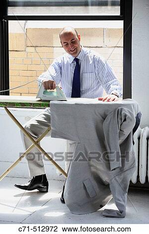 Businessman siiting on radiator ironing his jacket View Large Photo Image Stock Image - Businessman siiting on radiator ironing his jacket. Fotosearch