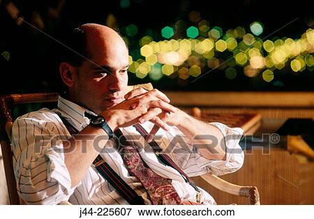 Businessman sitting on a terrace late at night View Large Photo Image Stock Photo - Businessman sitting on a terrace late at night. Fotosearch