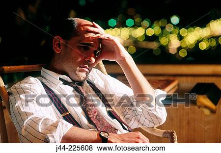 Businessman sitting on a terrace late at night View Large Photo Image Stock Photo - Businessman sitting on a terrace late at night. Fotosearch