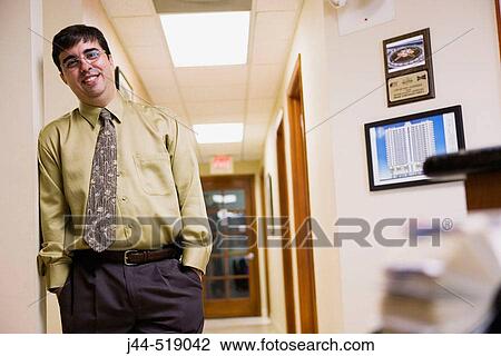 Businessman standing in hallway in an office View Large Photo Image Stock Image - Businessman standing in hallway in an office. Fotosearch