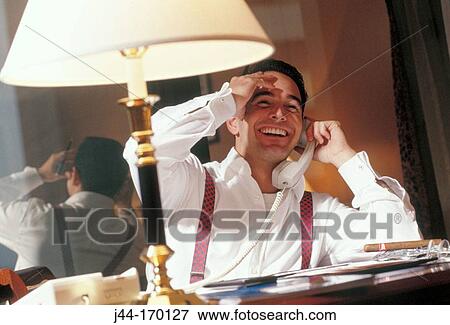 Businessman talking on the phone in a hotel room View Large Photo Image Stock Photo - Businessman talking on the phone in a hotel room. Fotosearch