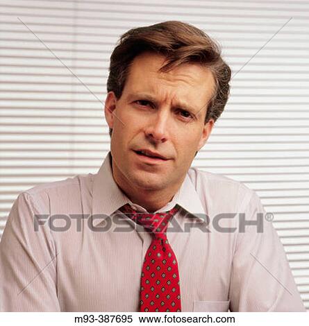 Businessman; tie loosened; blinds in background; looking concerned or confused View Large Photo Image Stock Photography - Businessman; tie loosened; blinds in background; looking concerned or confused. Fotosearch