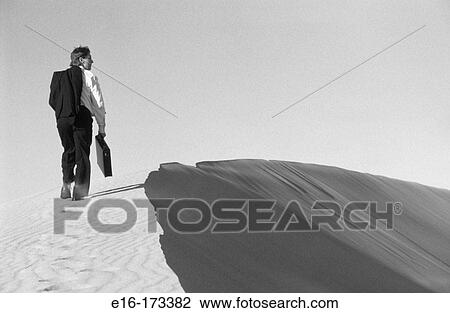 Businessman walking across dunes View Large Photo Image Stock Image - Businessman walking across dunes. Fotosearch