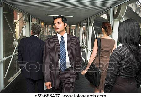 Businessman walking against the flow of other business people View Large Photo Image Stock Photo - Businessman walking against the flow of other business people. Fotosearch