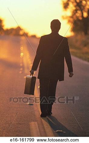 Businessman walking down road View Large Photo Image Stock Photo - Businessman walking down road. Fotosearch