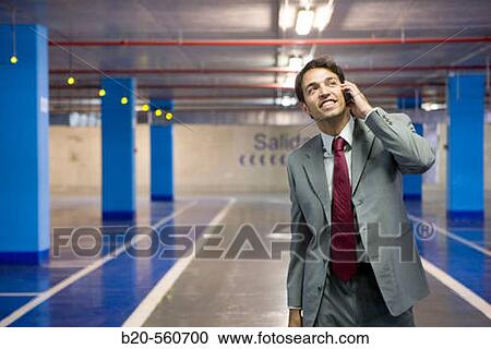 Businessman with mobile phone. Parking lot. View Large Photo Image Stock Image - Businessman with mobile phone. Parking lot.. Fotosearch