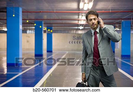 Businessman with mobile phone. Parking lot. View Large Photo Image Stock Image - Businessman with mobile phone. Parking lot.. Fotosearch