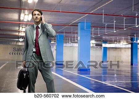 Businessman with mobile phone. Parking lot. View Large Photo Image Stock Image - Businessman with mobile phone. Parking lot.. Fotosearch