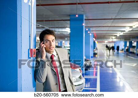 Businessman with mobile phone. Parking lot. View Large Photo Image Stock Photography - Businessman with mobile phone. Parking lot.. Fotosearch