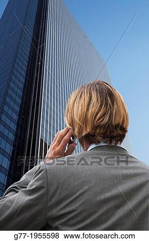 Businessman with phone under high rise building. New York. Usa. View Large Photo Image Stock Photo - Businessman with phone under high rise building. New York. Usa.. Fotosearch