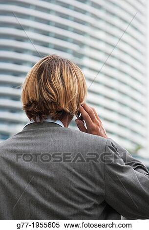 Businessman with phone under high rise building. New York, USA View Large Photo Image Stock Photography - Businessman with phone under high rise building. New York, USA. Fotosearch