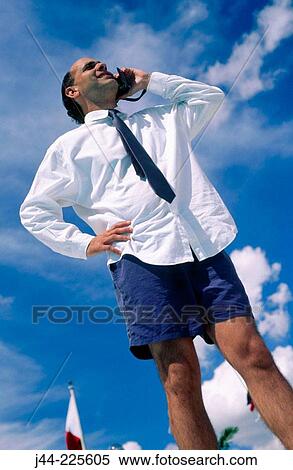 Stock Photography - Businessman with shirt, tie and shorts talking on cell phone. Fotosearch